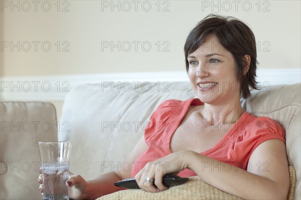 Caucasian woman on sofa watching television