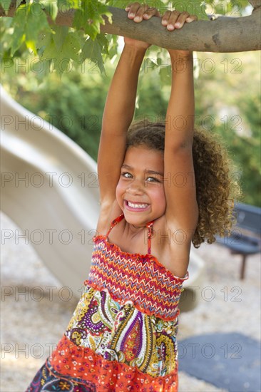 Mixed race girl playing on playground