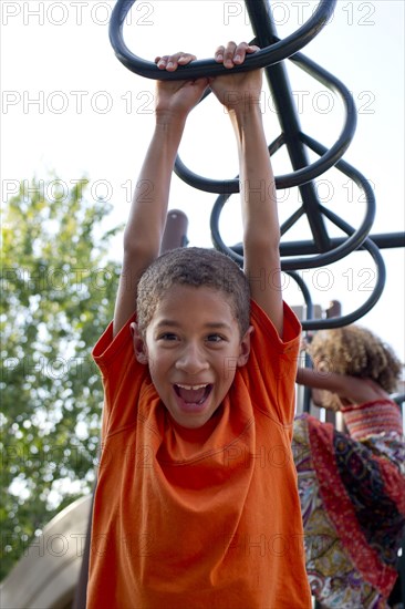 Mixed race boy playing on playground