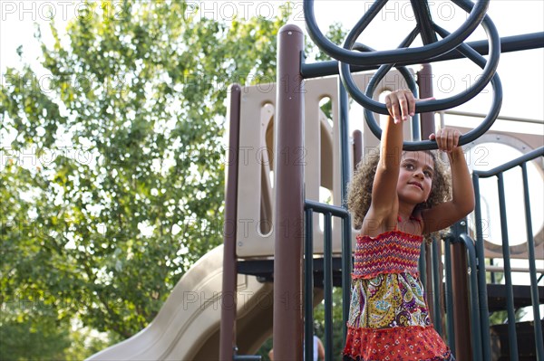 Mixed race girl playing on playground