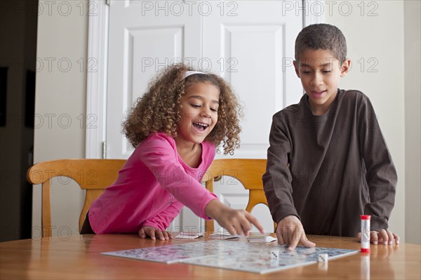 Mixed race children playing board game together