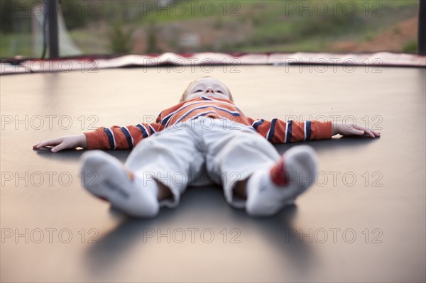 Caucasian boy laying on trampoline