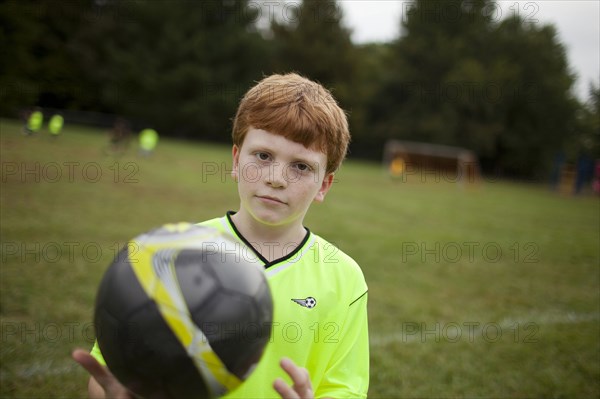 Caucasian boy playing soccer on field