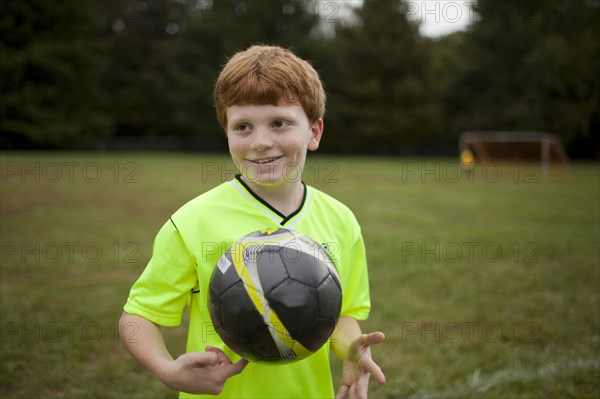 Caucasian boy playing soccer on field