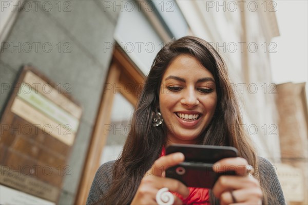 Mixed race woman using cell phone outdoors