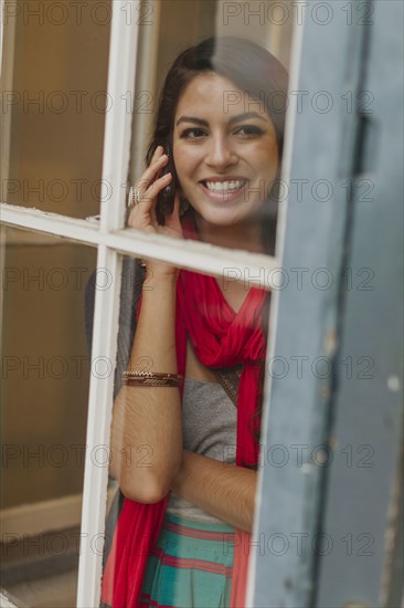 Mixed race woman talking on cell phone on city street