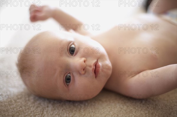Caucasian baby laying on carpet