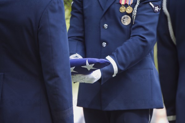 Soldiers folding flag at military funeral