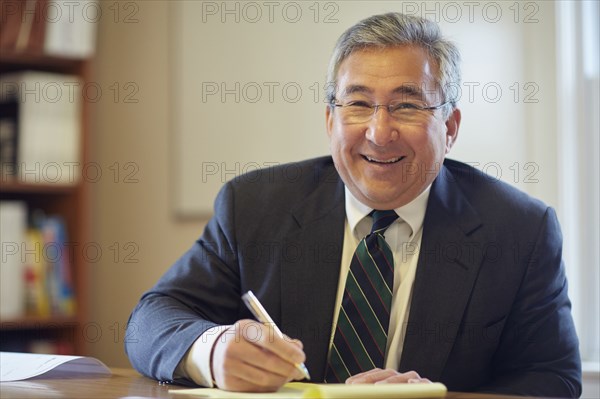 Mixed race businessman smiling at desk in office