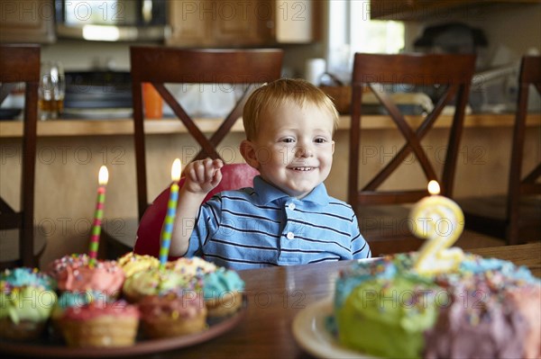 Caucasian boy admiring birthday cake