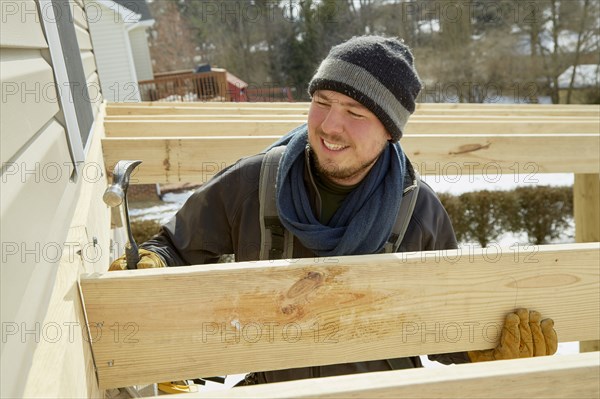 Caucasian carpenter building house extension in winter