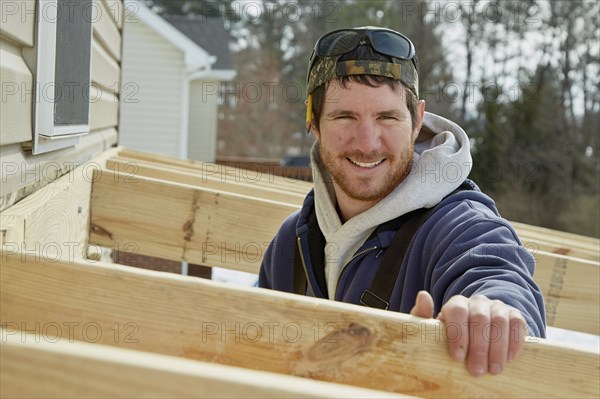 Caucasian carpenter building house extension in winter