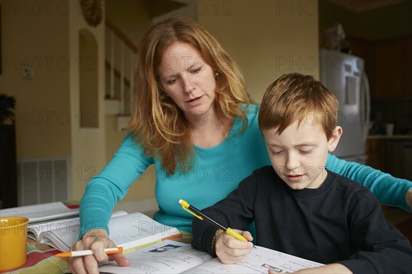 Caucasian mother helping son do homework