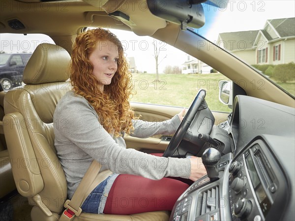 Caucasian teenage girl driving car