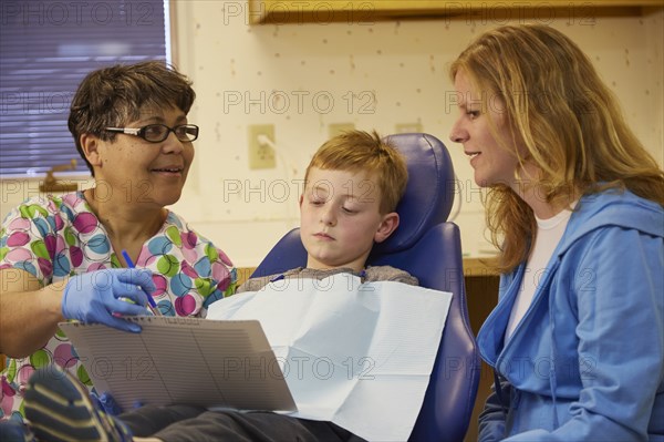 Pediatric dentist talking to patient and mother