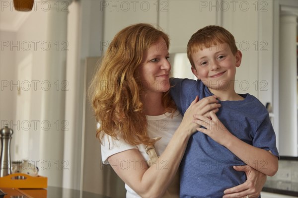 Caucasian mother and son smiling in kitchen