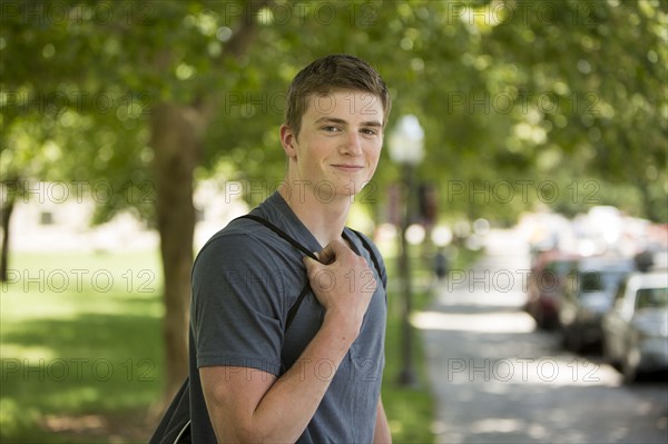 Caucasian student smiling on sidewalk