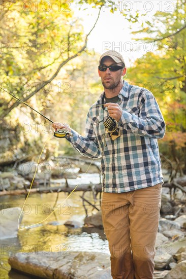 Caucasian man fishing in forest steam