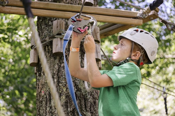 Caucasian boy hooking harness to zip