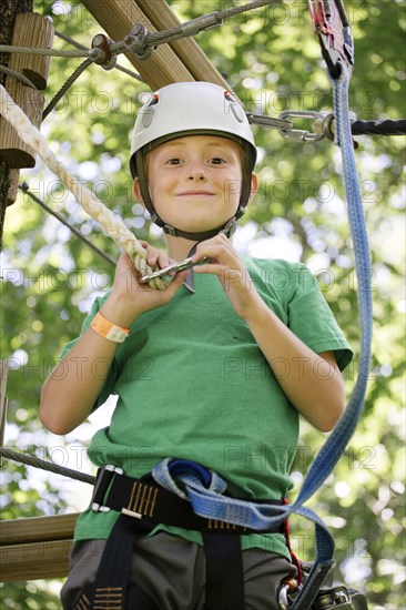 Caucasian boy hooking harness to line