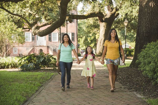 Hispanic mother and daughters walking in park