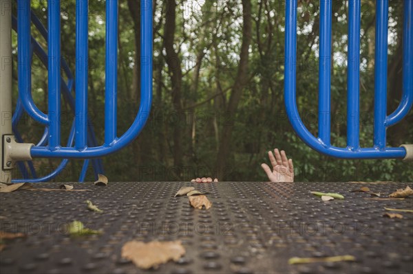 Hands of Hispanic girl reaching on playground