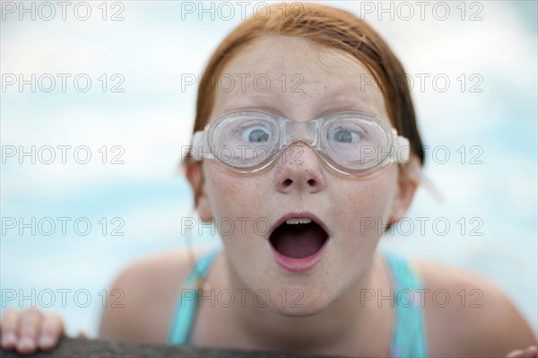 Portrait of surprised Caucasian girl wearing swimming goggles