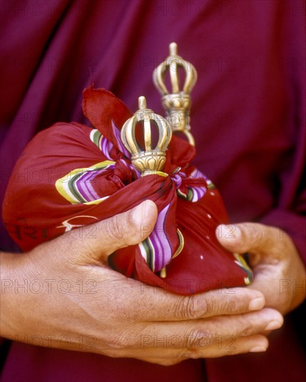 Close up of hands holding ceremonial bells