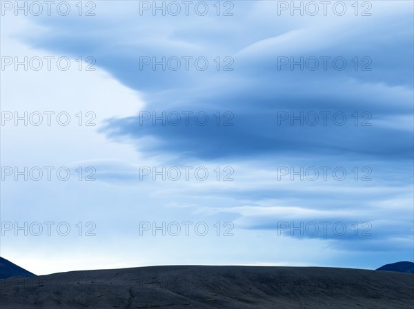 Silhouette of mountain range under cloudy sky