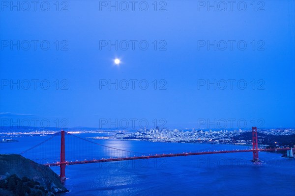 Moon in night sky over Golden Gate Bridge