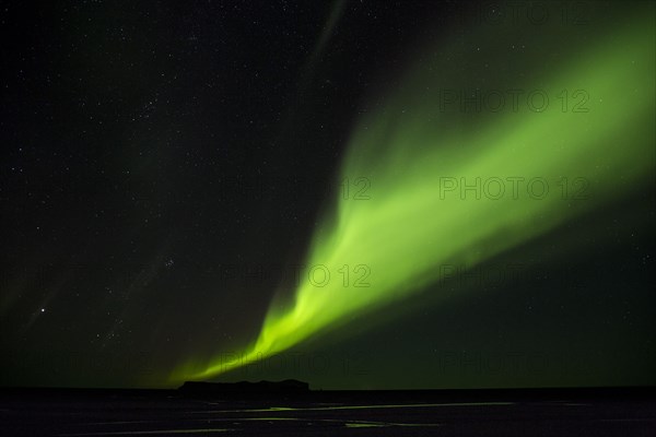 Northern Lights glowing green in night sky