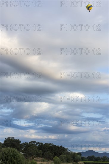 Hot air balloon flying over rural landscape