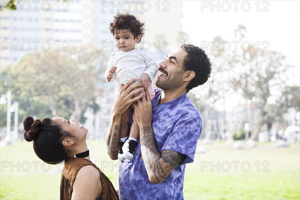 Parents playing with baby son in park