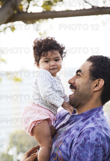 Father holding baby son outdoors