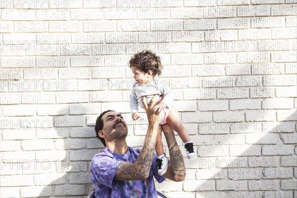 Father playing with baby son outdoors