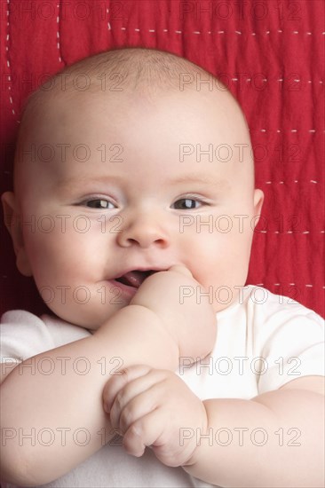 Caucasian baby biting hand