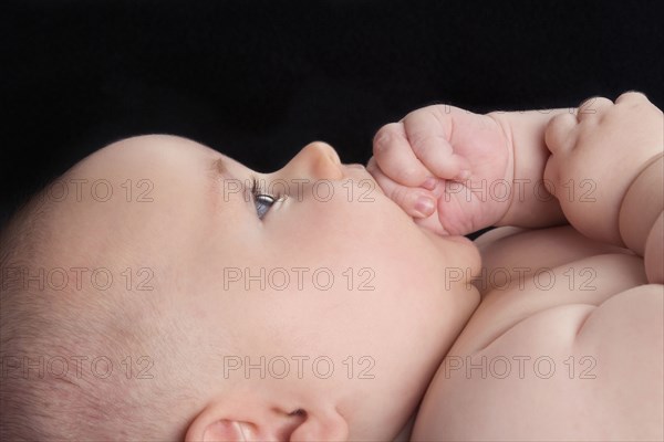 Caucasian baby biting  hand