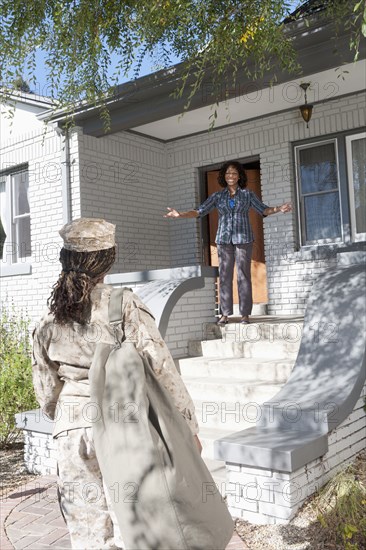 Black mother greeting soldier daughter