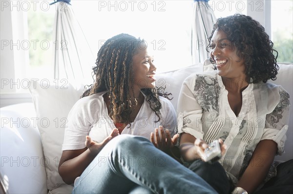 Black mother and daughter watching television together