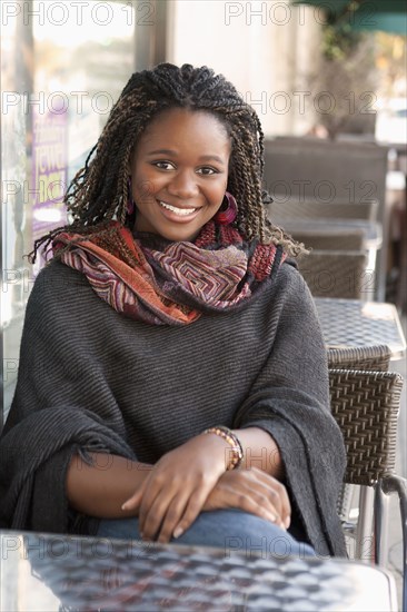 Black woman sitting at outdoor cafe