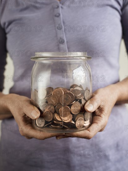 Caucasian woman holding jar of coins