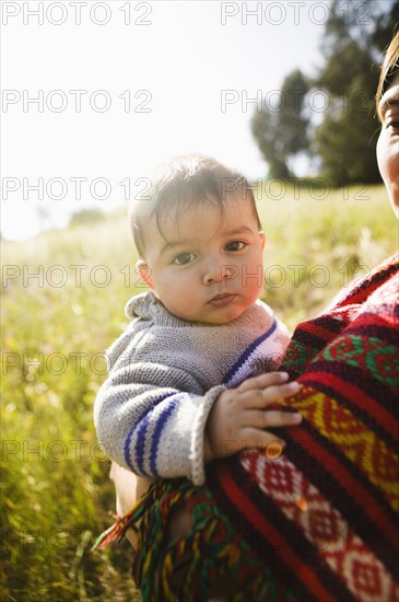 Mother holding baby in field