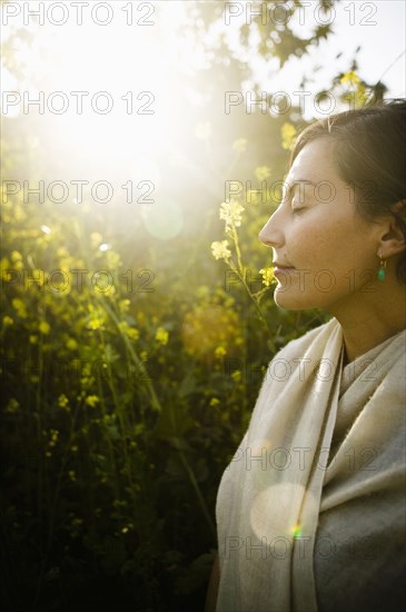Mixed race woman with eyes closed in field