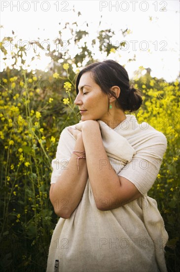 Mixed race woman with eyes closed in field