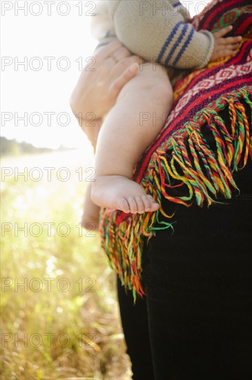 Mother holding baby in field