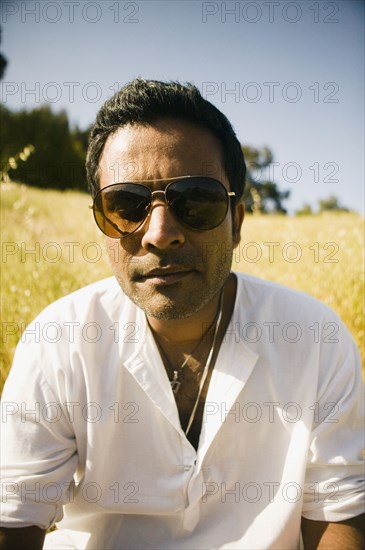 Serious mixed race man in field