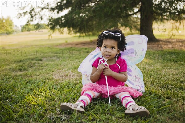 Black baby girl in fairy costume in park