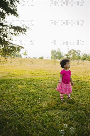 Black baby girl standing in park