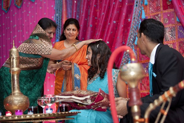 Indian woman blessing Indian bride