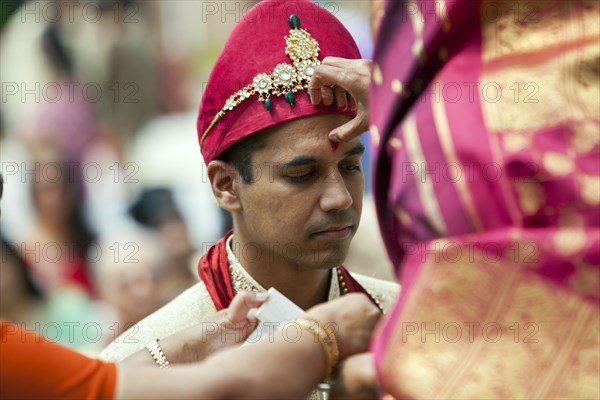Indian woman marking groom's forehead